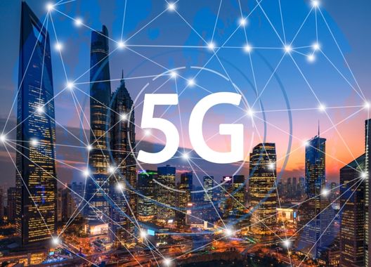 Uma fotografia de uma cidade com uma animação de uma rede interligada ilustrando a conexão 5g, algo que pode revolucionar a tecnologia industrial