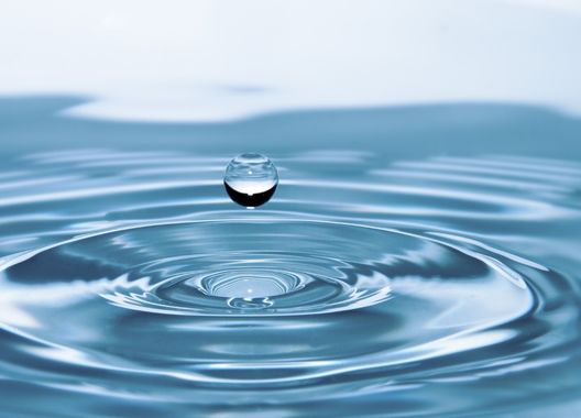 Uma fotografia de uma gota de água caindo sobre rio potável