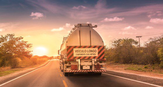 Uma caminhão transportando um produto perigoso referente aos riscos da poluição do solo.