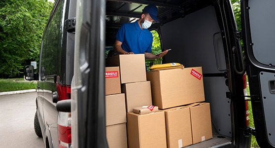 Uma fotografia de um homem separando as caixas de entregas.
