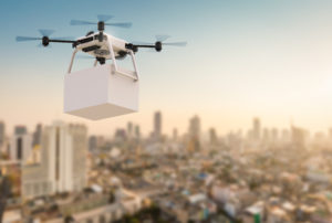 drone de transporte levando encomenda na cidade com o sol nascendo.