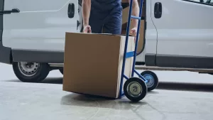 Entregador de cargas carregando caixas, exemplo de economia compartilhada