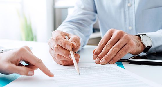 Uma fotografia de um corretor mostrando com a caneta uma cláusula de seguro reforçando o que é um endosso