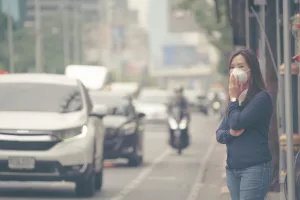 Mulher com máscara na cidade devido à poluição do ar