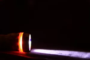 lanterna acessa em local escuro representando queda de energia