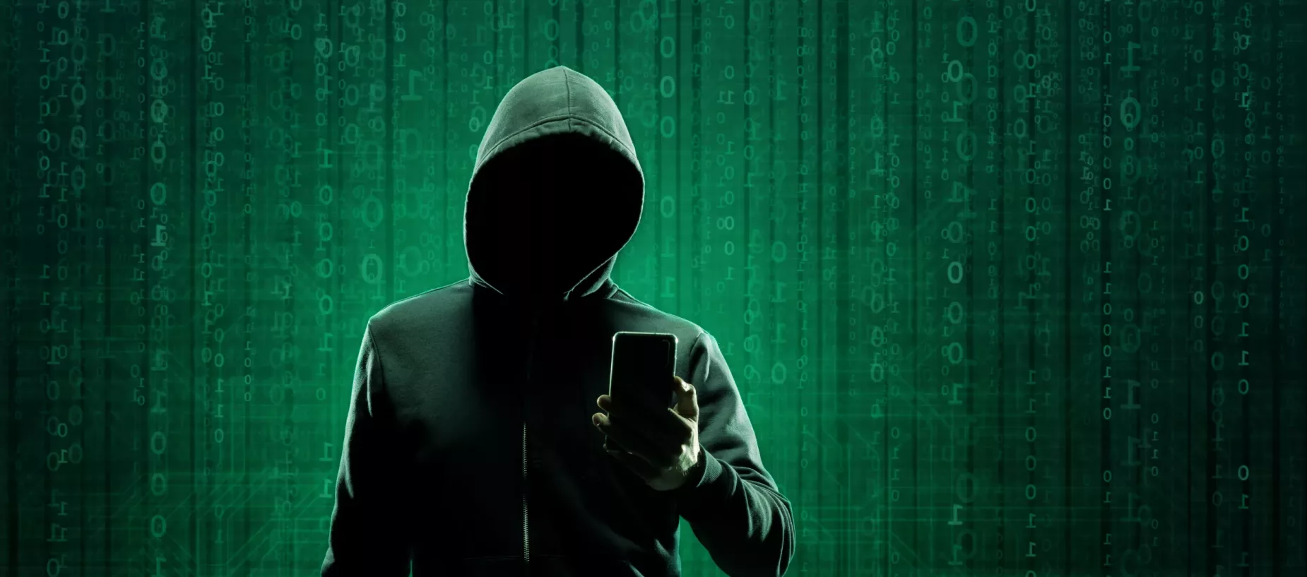 hacker com capuz sem rosto visível com dados em verde ao fundo