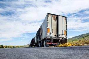 caminhão em rodovia com porta container meio aberto sinalizando que houve roubo de cargas.