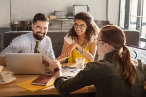 Pessoas em sala de reunião sorrindo discutindo sobre assuntos profissionais,